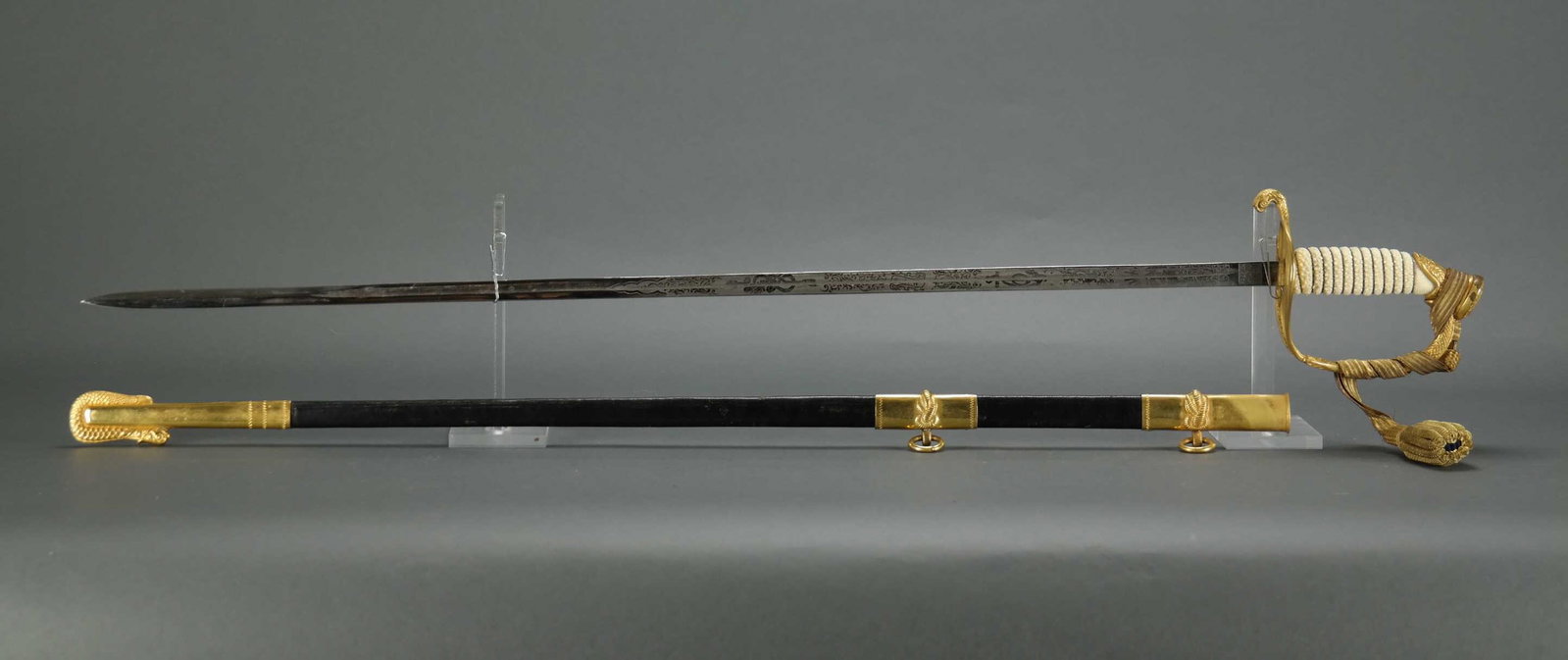 US Naval Officer's Sword. With Belt And Strap.: [Edged Weapons] US Naval Officer's Sword. With engravings on both sides of the blade. No number stamped on sheath. Fabrica De Toledo. With tassel, belt, and strap._x000D_ Condition Light wear to leath