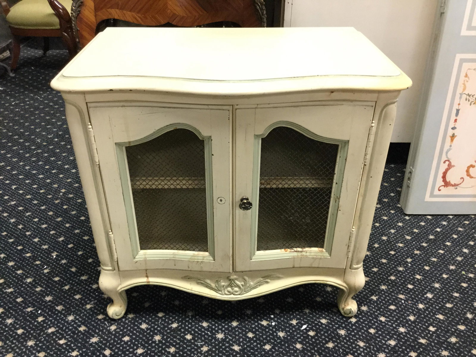 French Provincial style 2-door cabinet: French Provincial style two-door cabinet. Metal grill front door panels. Left door knob missing.