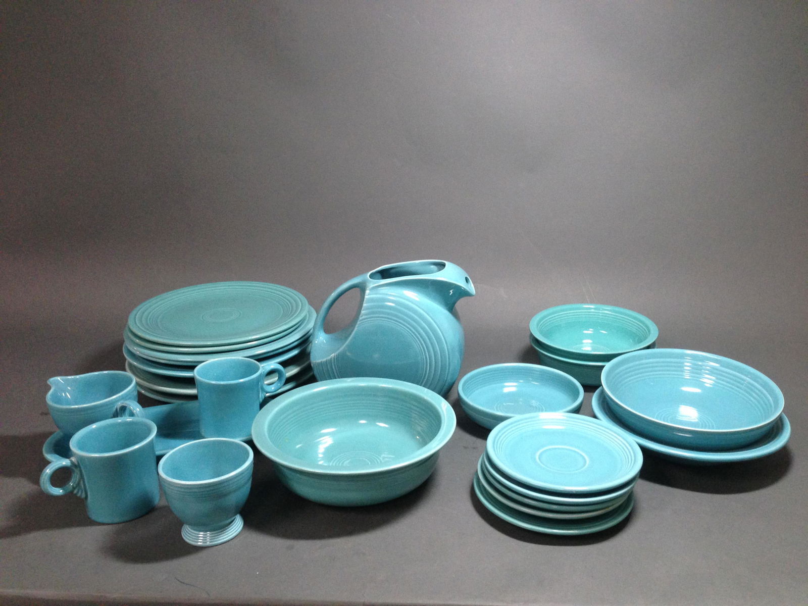 24 Vintage Homer Laughlin Fiestaware Pieces: 24 Vintage Homer Laughlin Turquoise Fiestaware Pieces Condition: Vegetable bowl has damage to one side. 1 dinner plate has scuff on reverse.