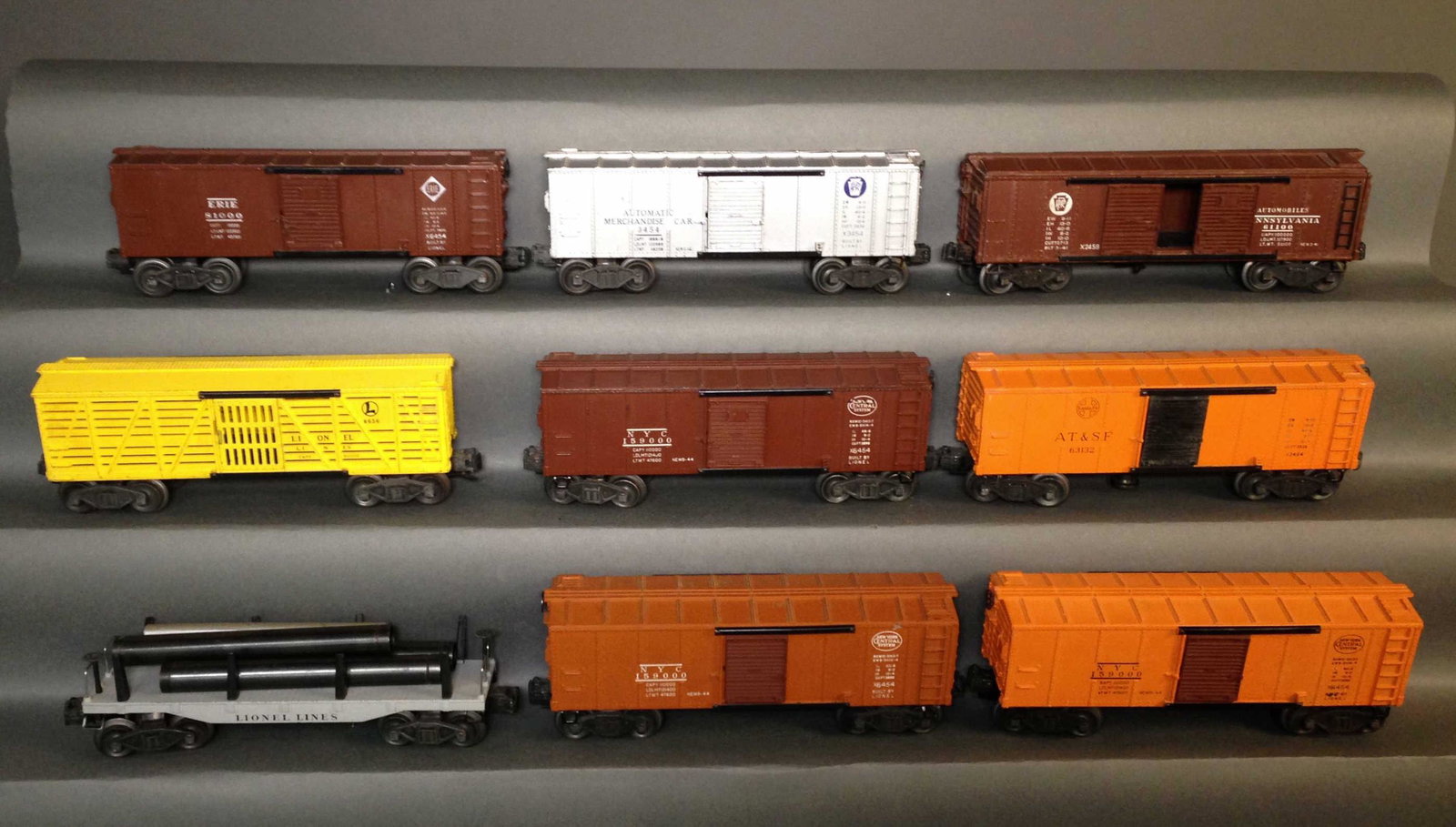 Nine Postwar Staple Truck Lionel Model Train Cars: Nine Postwar Staple Truck Lionel Model Train Cars ++ Erie 6454, 3454 Automatic Merchandise box car, 2458 Pennsylvania box car, 6656 Stock car, 6454 NYC box car, 3464, A.T. & S.F. box car, 2411 gondola