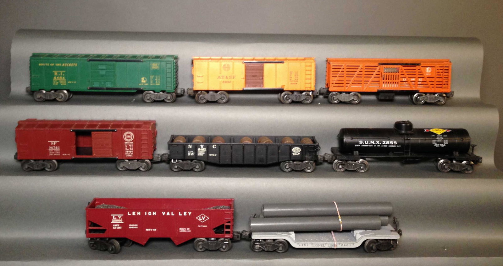 Eight Postwar Staple Truck Lionel Model Train Cars: Eight Postwar Staple Truck Lionel Model Train Cars ++ 6464-75 Rock Island box car, 6464 A.T. & S.F. box car, 6462 NYC gondola, 6456 Lehigh Valley hopper, 2461 transformer car missing transformer, 2955