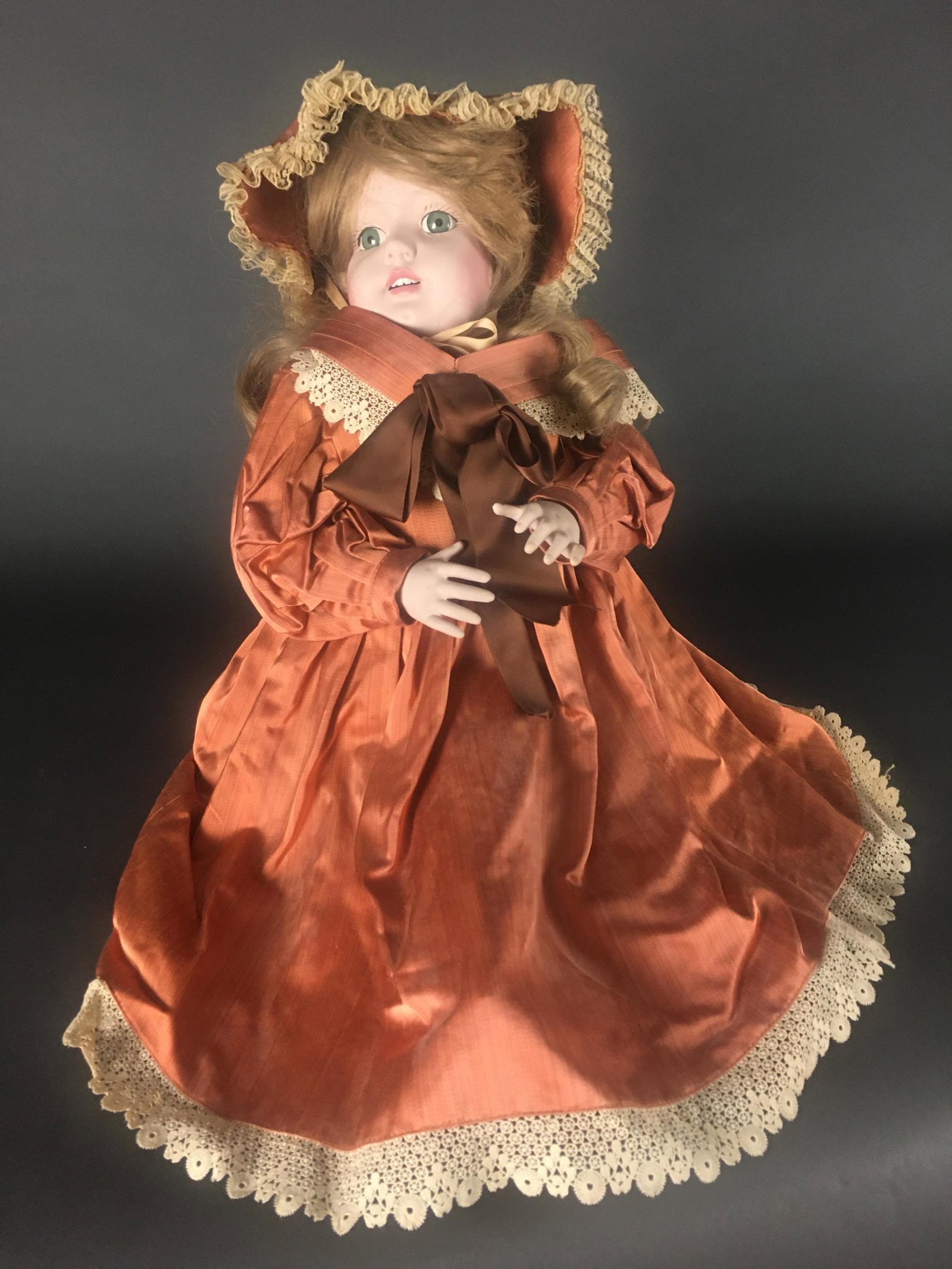 2 Baby Dolls & Flapper. 1 wind up.: (1) 18" long. In orange frock and bonnet. Marked with an "R" on the uppear back portion of neck. (2) 14 1/2" long. In floral frock and bonnet. With wind up key in back to play music. (3) Unmarked 1920