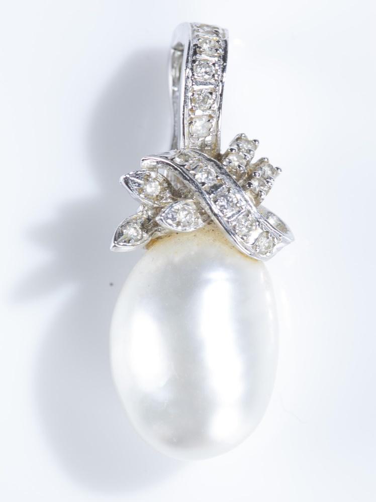 Baroque pearl 14k gold enhancer pendant.: A baroque pearl and diamond 14k gold enhancer pendant. Diamonds set in 14k white gold knot shaped enhancer pendant. Marked on back. 1 1/4" x 1/2". Approx. 6.3 g.