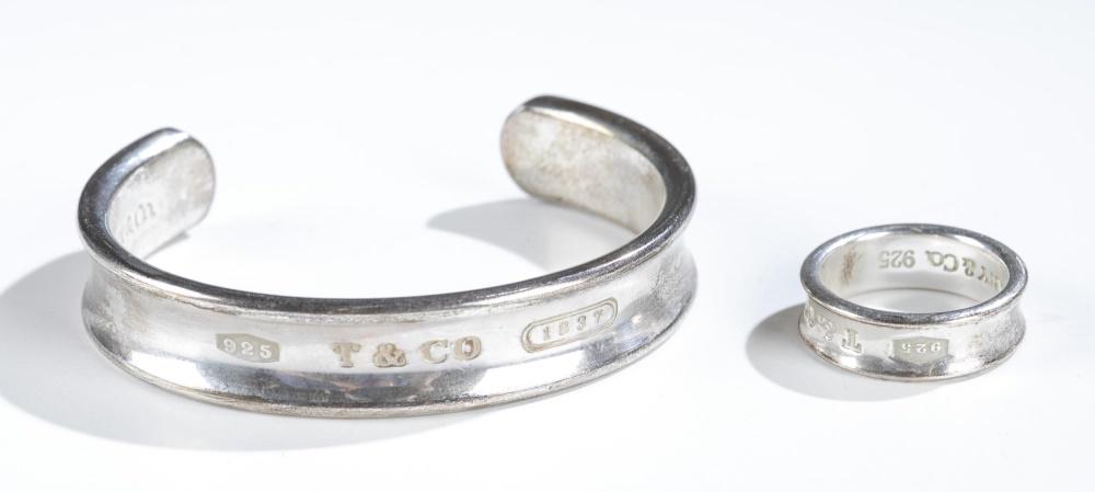 Tiffany & Co., 1837 collection ring & bracelet.: A group of two pieces of Tiffany & Co sterling silver jewelry from the 1837 collection. 1997. Stamped interior and exterior. ++ Open cuff bracelet. 1/2" x 2 1/4". Approx, 43g. ++ Concave band ring. 7 