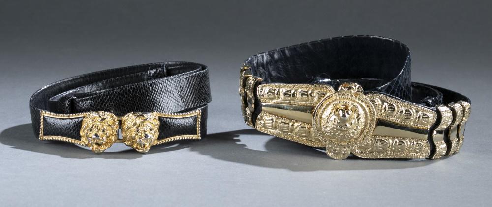 2 Judith Leiber, belts.: A group of two Judith Leiber black belts. Gold tone hardware. Marked on interior. Includes two dust covers. ++ Lion head belt. Overall 38". ++ Double lion head belt. Overall 36".