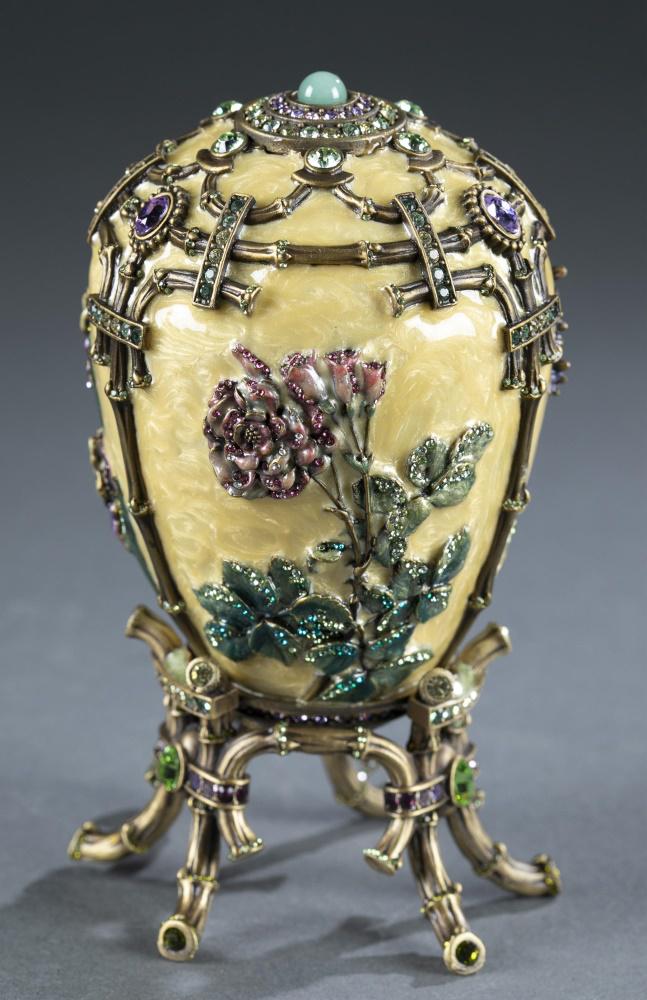 Jay Strongwater decorative egg.: A Jay Strongwater enameled decorative egg on stand. Pale yellow enamel decorated with flowers and rhinestones Raised on enameled and jeweled bamboo style stand. Limited Edition 125/450. Marked on base