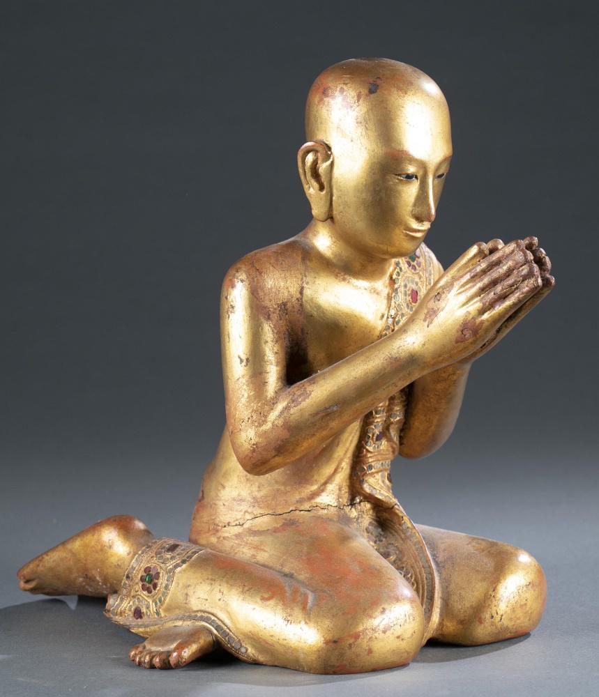 Burmese gilt wood kneeling Buddhist attendant.: A Burmese gilt wood kneeling Buddhist attendant (monk). Lacquer and gilt over wood with inlaid glass. Depicted kneeling with eyes closed and hands in namaskara mudra. 11 3/4" x 7 7/8" x 10 1/4"._x000D