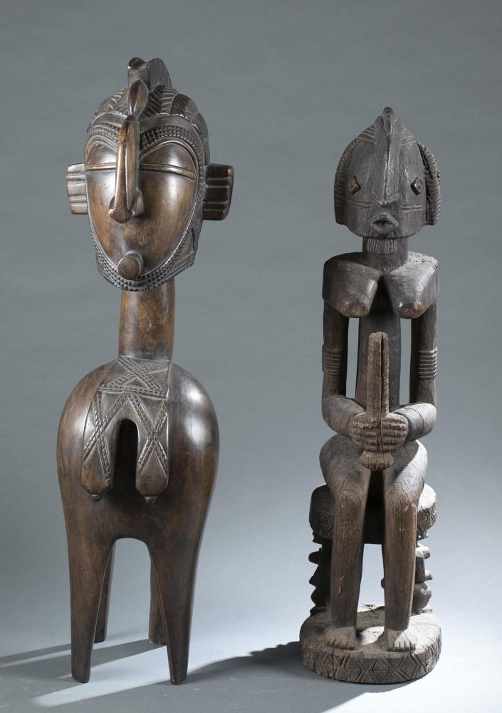 2 West African Style Wooden Figures. 20th c.: A group of two West African style wooden figures. 20th century. ++ Baga Nimba style figure. 41" x 11" x 15". ++ Dogon style figure. 38" x 10" x 10 3/4". Accretions, cracks, and wear throughout. Condit