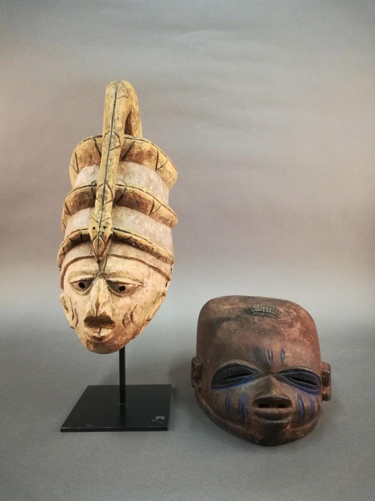 2 Yoruba Style Gelede Society Masks. 20th c.: A group of two Yoruba style Gelede Society masks. 20th century. West Africa. Larger 17 1/4" x 6 1/2" x 10 1/2". Smaller 6 1/4" x 9" x 12 1/2". Includes stand.