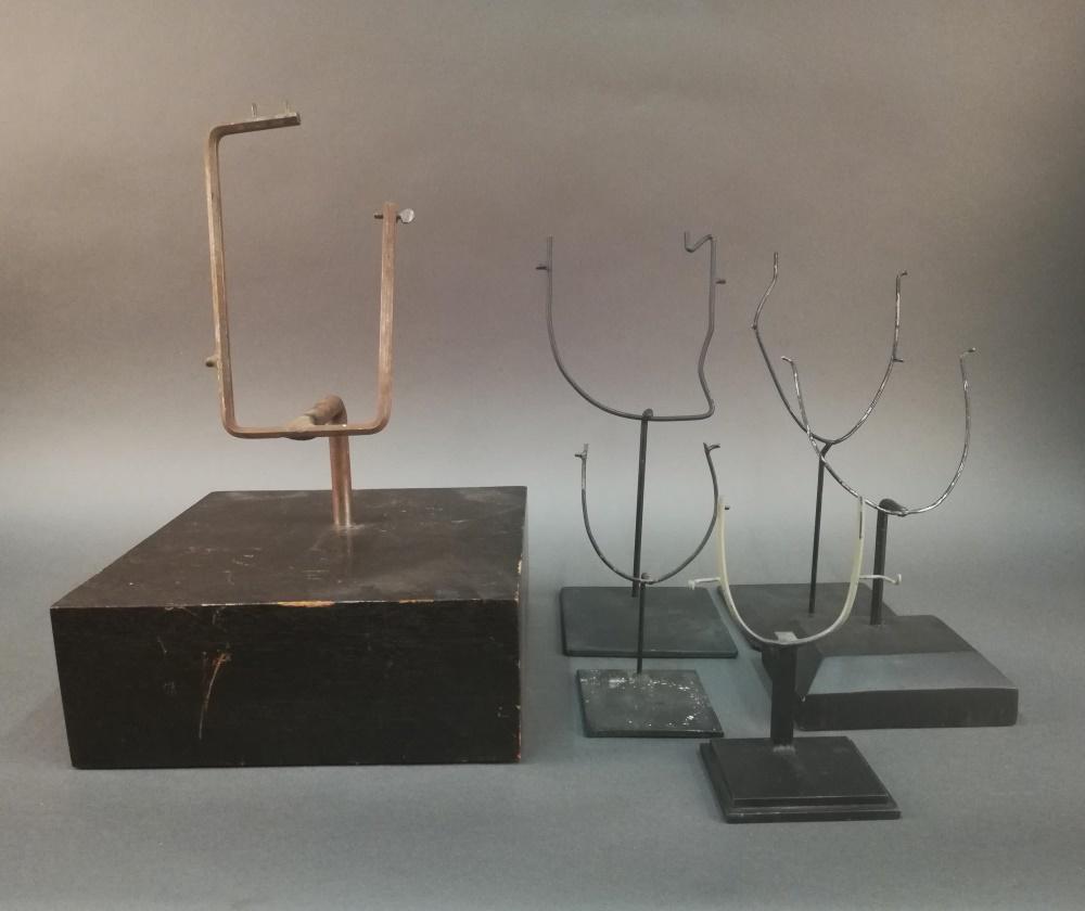 6 Mask Display Stands.: A group of six mask display stands of various sizes, shapes, and materials. Largest: 18" x 12" x 12". Smallest: 7 3/4" x 4 1/4" x 3 1/2"