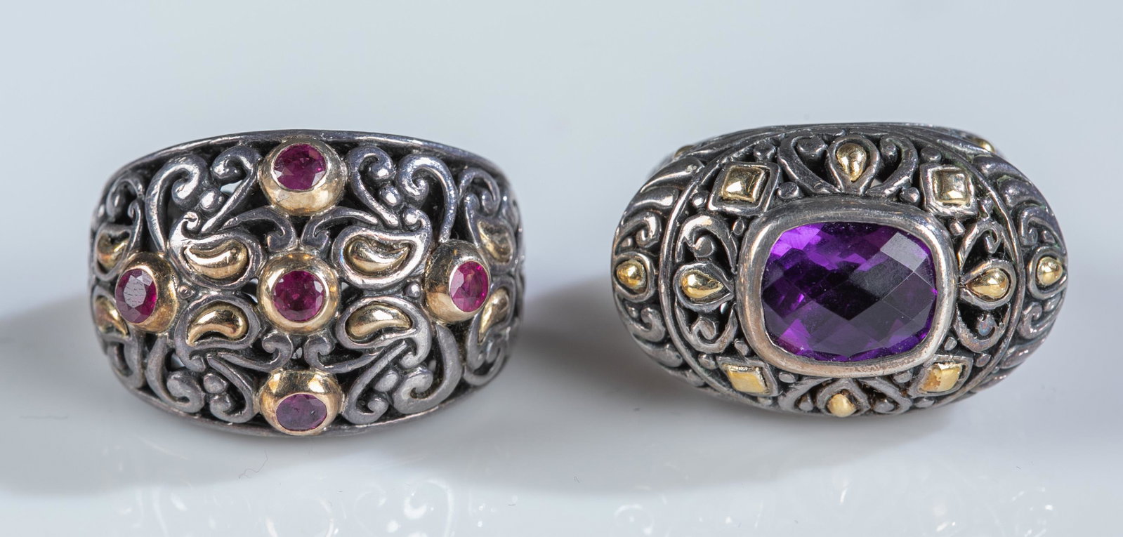 2 BJC 18k gold on sterling silver rings.: A group of two Samuel Benham BJC 18k gold on sterling silver cocktail rings. Stamped "925 BJC 18k" inside band. ++Amythest ring. Size 6. Approximately 17.8g. ++Ring with five small red gemstones. Size