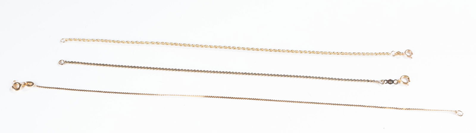 3 14k Gold chain bracelets.: A group of three 14k yellow gold chain bracelets with springring clasps. Stamped on clasps. Approximately 3.7g. ++Rope chain. Stamped "14kt Italy OR". 7". ++ Flat S chain. Stamped "Italy 585 16 AR". 9