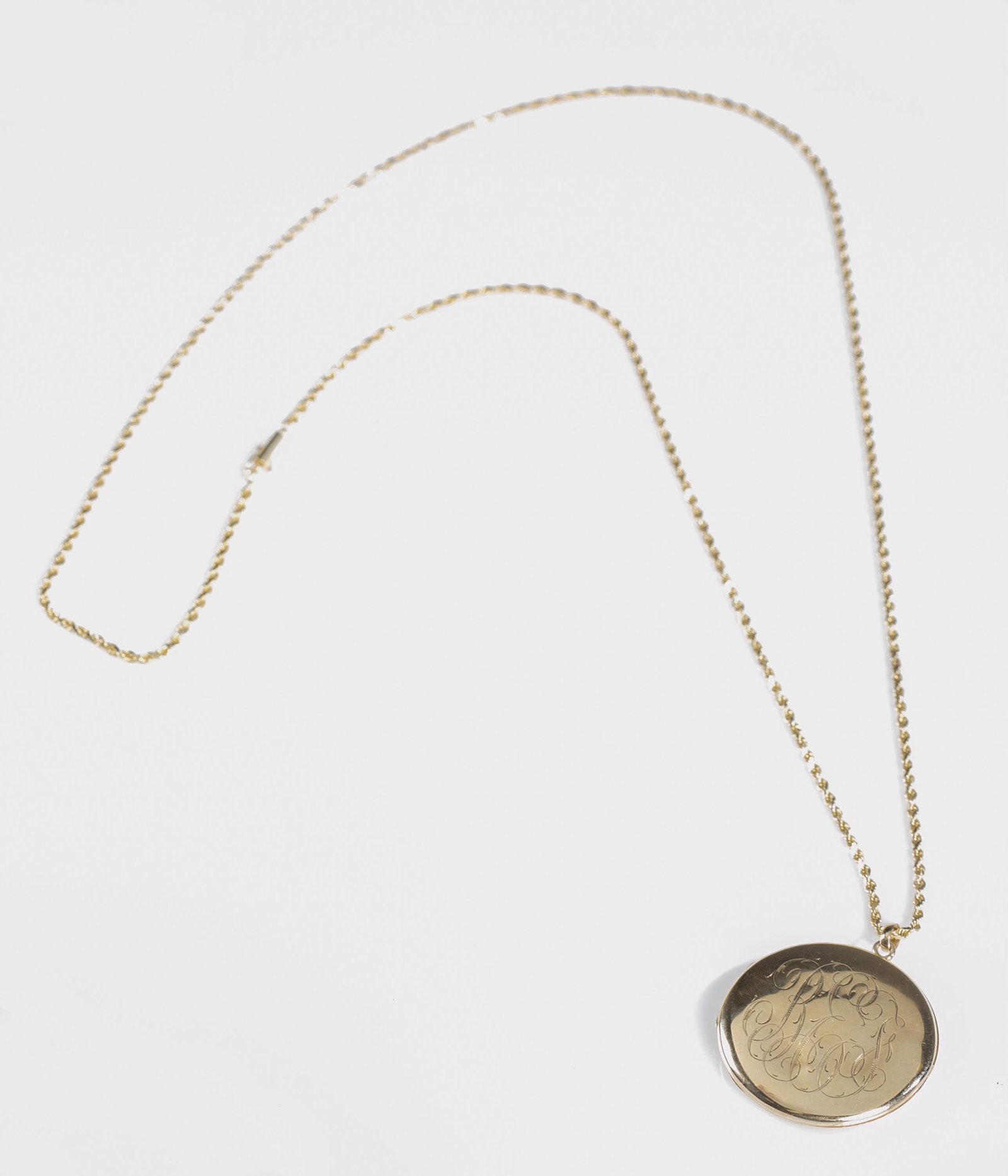14k Gold necklace with 10k locket.: A 14k yellow gold rope chain necklace with bayonet clasp and 10k yellow gold monogrammed locket. Stamped "10k" inside locket. Tested 14k. Chain: approximately 30" and 11.2g. Locket: 1 1/2" dia and 8.8