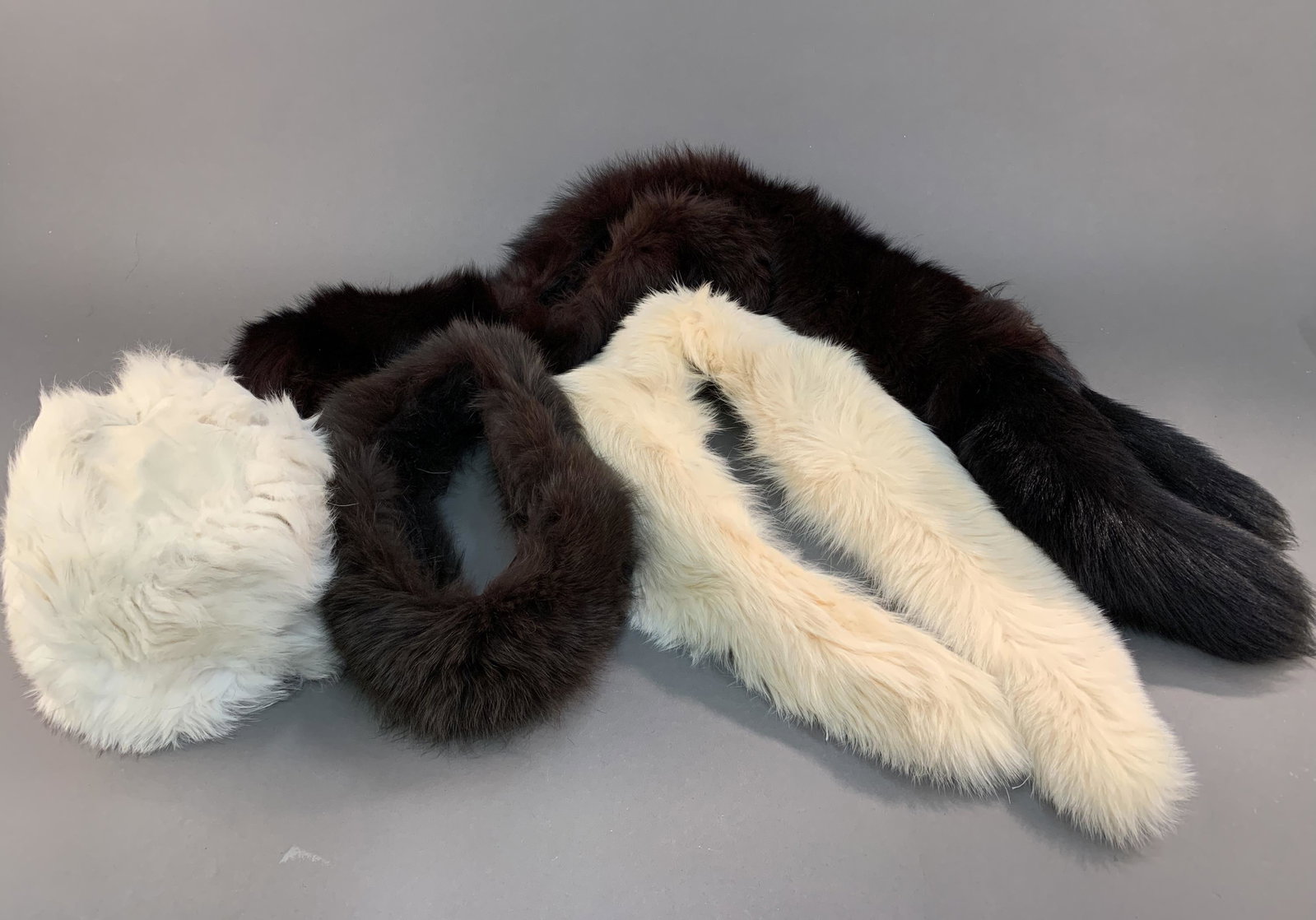 4 Fur accessories.: A group of four fur accessories. ++ Filippidis Furs & Leathers ermine fur pill box hat. 6". Circumference: Approx, 26". ++ White fox fur scarf. Silk lining. Threads of lining loose. 36". ++ Brown fox 