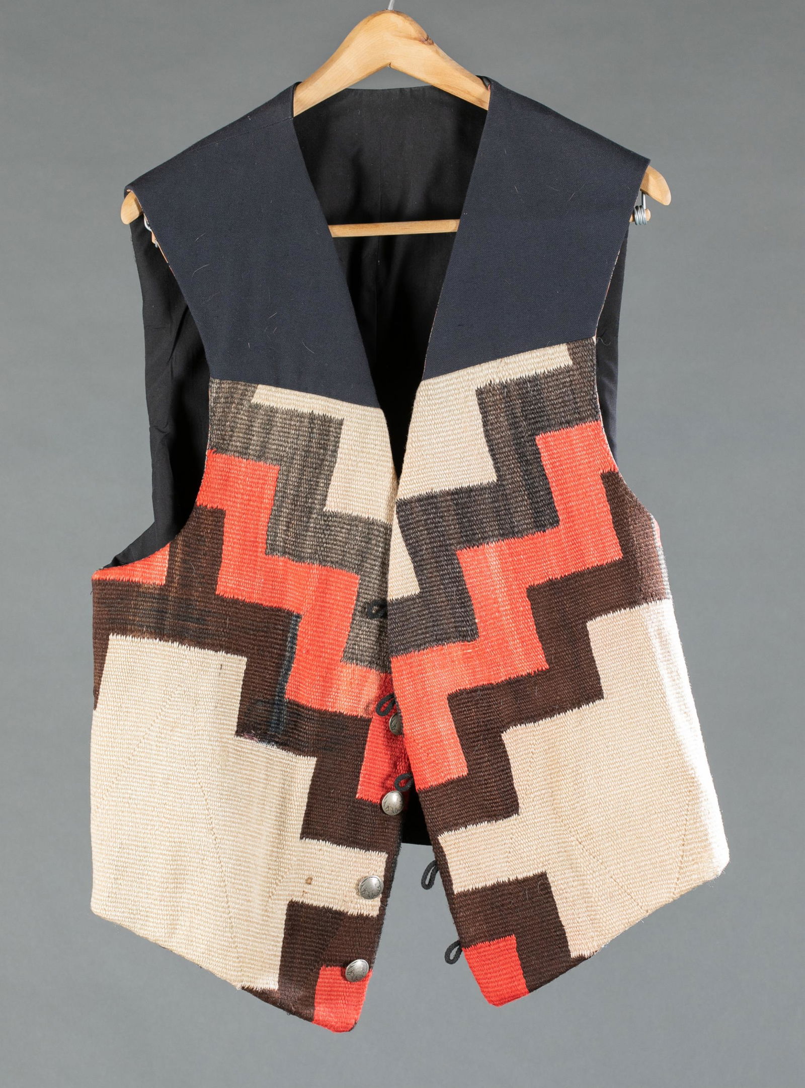 Navajo woven vest.: A navy blue vest with Navajo style woven front. Design by Hester, Sante Fe, NM. Five buffalo nickel buttons. Lined interior. Two interior pockets. Approximately: Length: 26 1/2" Bust: 48". Condition:
