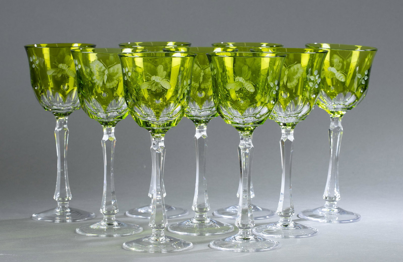 9 Varga "Springtime" glass goblets.: A group of nine Varga contemporary "Springtime" pattern yellow-green cut glass water goblets. Intricate cut butterflies and bees throughout the bowl of the goblets. Incised "Varga" to the underside. 8