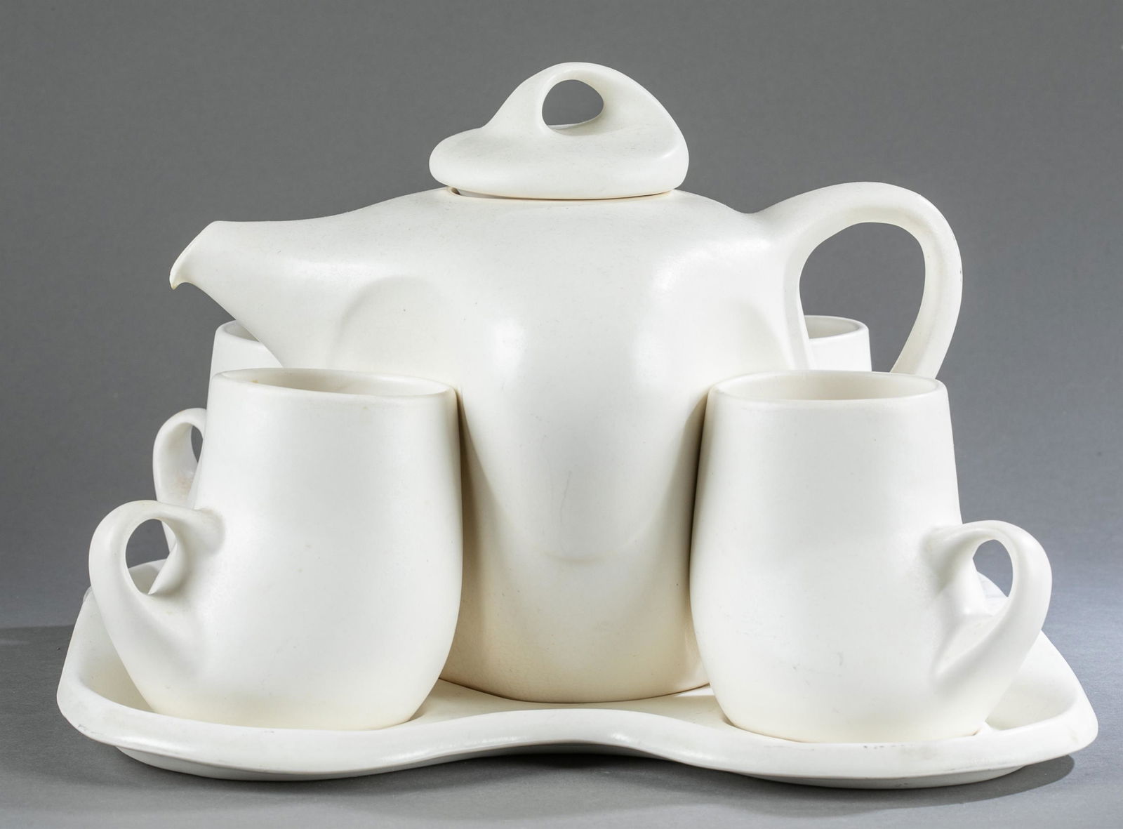 Peter Saenger, nesting Design II, tea set.: A Peter Saenger nesting Design II six piece white matte porcelain tea set. ++Tray 10" x 9". ++Tea pot 8" x 9 1/2" x 8". ++Four cups 4 1/4" x 4" x 3 1/2". Shipping: This lot does not qualify for in hou