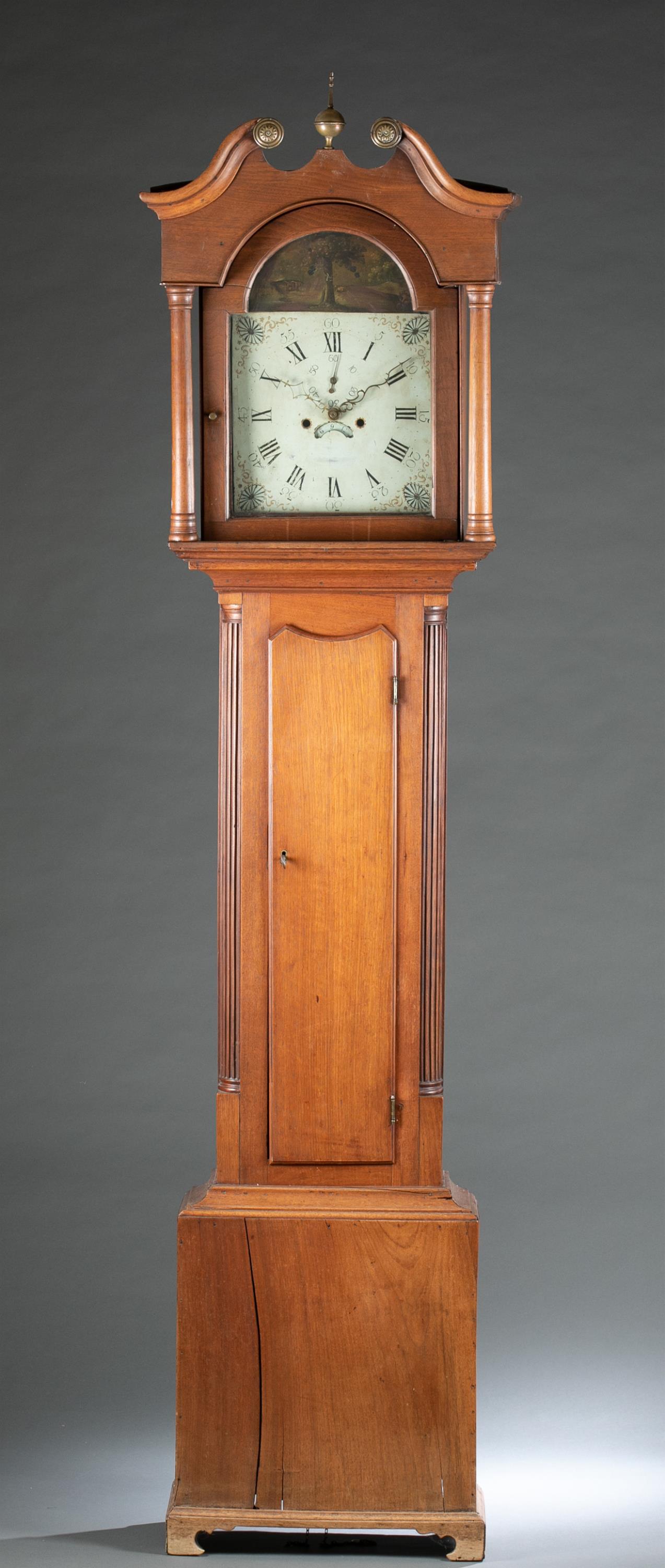 American Federal walnut tall case clock, 19th c.: An American Federal tall case clock. Probably from Pennsylvania. 19th century. Hepplewhite style case, topped with broken scroll pediment. Columns flank glass door. Painted dial with Roman numerals an