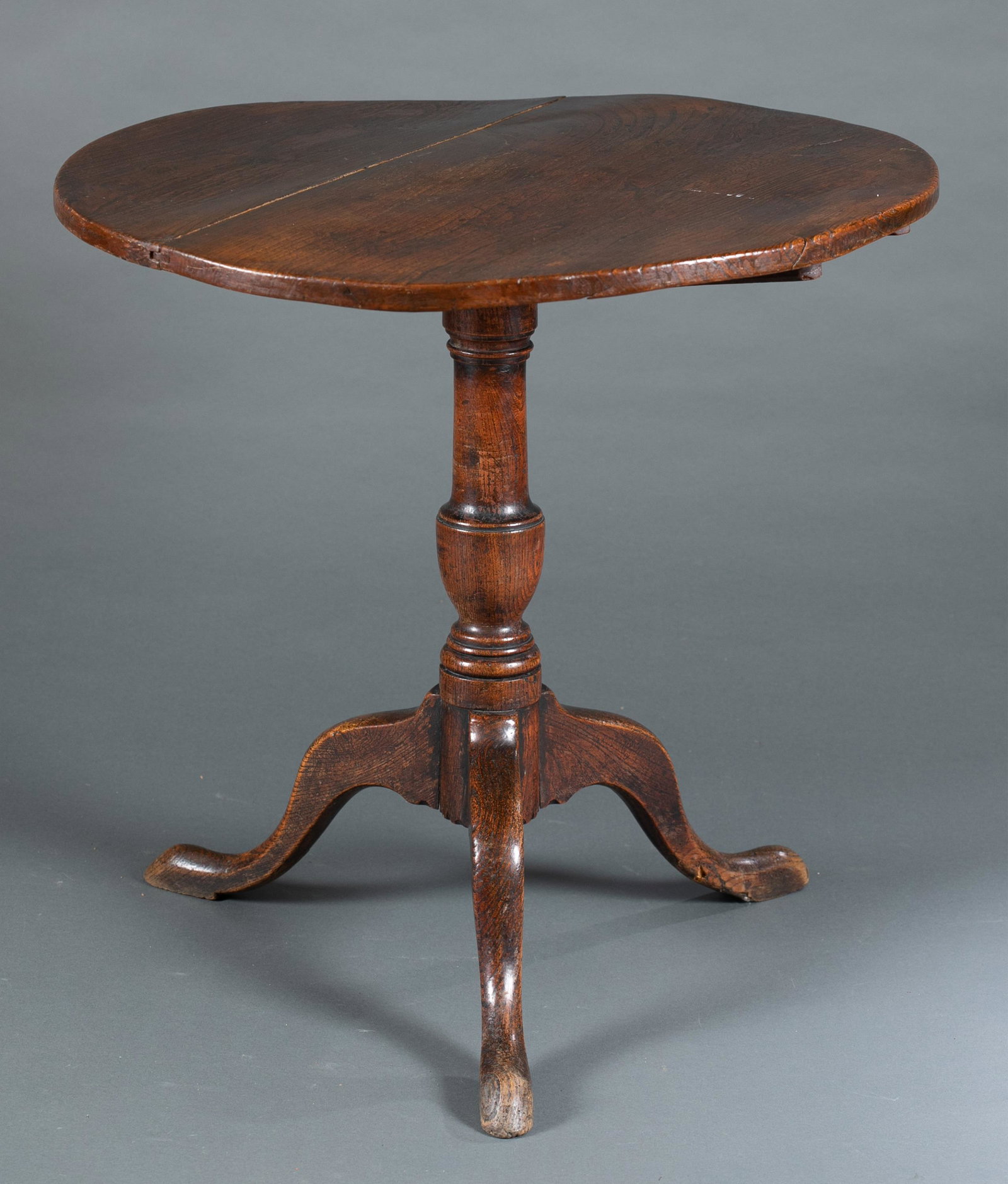 Queen Anne Mahogany tilt-top table, 18th c.: A Queen Anne mahogany tilt-top tea table. English, 18th century. Circular top on central pedestal that ends on tripod base. 29" x 20 3/4" x 20 3/4". Shipping: This lot does not qualify for in house sh