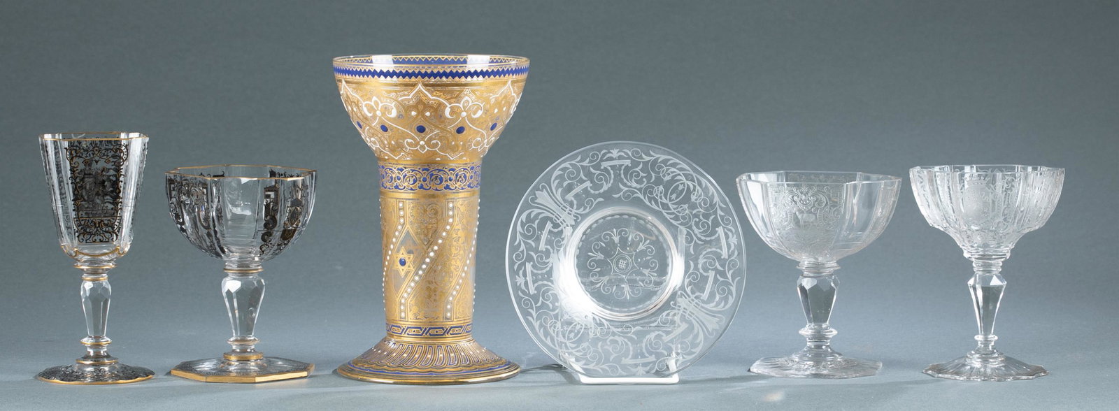 6 Lobmeyr glassware: A group of six pieces of Lobmeyr glassware, 19th century. Includes five cups and one plate. Smallest: 3" x 2 3/4" x 4 3/4". Largest: 4 1/2" x 4 1/2" x 7 1/4". Provenance: Provenance: From the Estate o