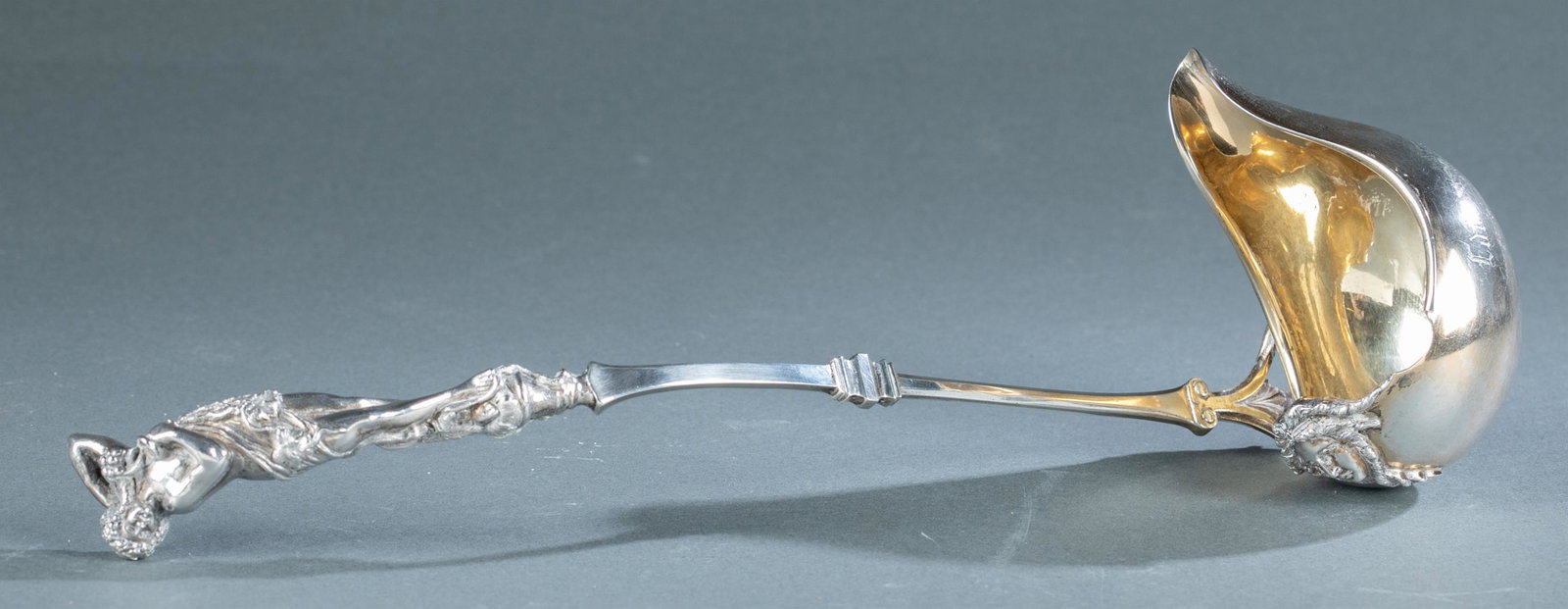 American silver figural punch ladle, 19th c.: An American unmarked silver figural punch ladle, circa 1872. Possibly by George B. Sharp, Philadelphia. Ladle has a gilt bowl decorated with a woman's head and has cast Classical nude woman at end of 