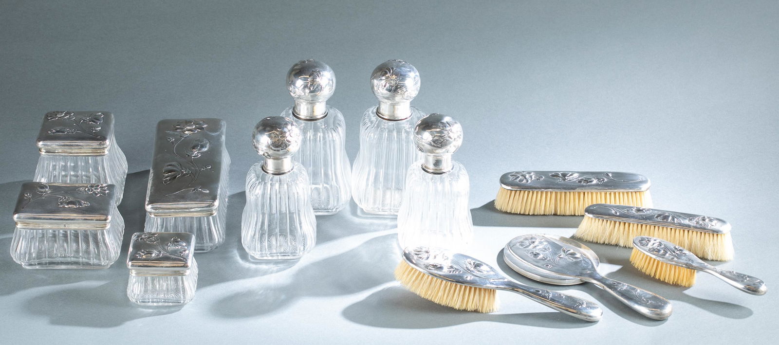 13 Piece French silver mounted dresser set.: A Simon Slisonski, Paris .950 silver standard mounted thirteen piece dresser set with floral motif, circa 1888-1903. Includes four cut glass dresser bottles of varying sizes, four cut glass dresser bo