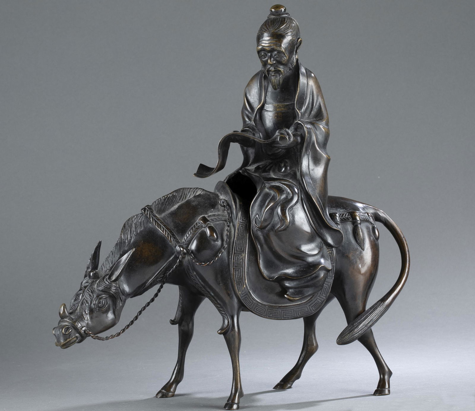 Japanese bronze of a scholar riding an ox, Meiji.: A Japanese bronze sculpture. Meiji period (1868-1912). A two piece sculpture depicting a scholar riding on an ox. Possibly a censer. Signed on belly of the ox. 15" x 14 1/2" x 4 1/2". Condition: Light