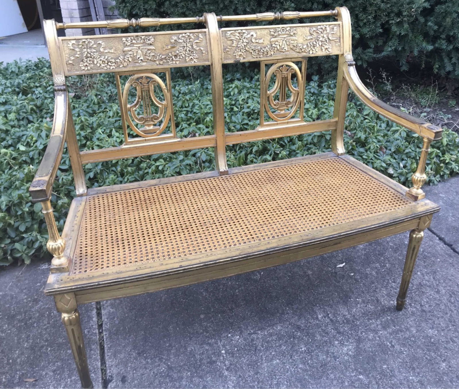 Italian Neoclassical settee, 19th c.: Italian Neoclassical gilt wood double lyre back settee, 19th century. With double lyre back splat beneath a relief laurel panels, cane seat, raised on straight fluted legs. Condition: Cane has been re