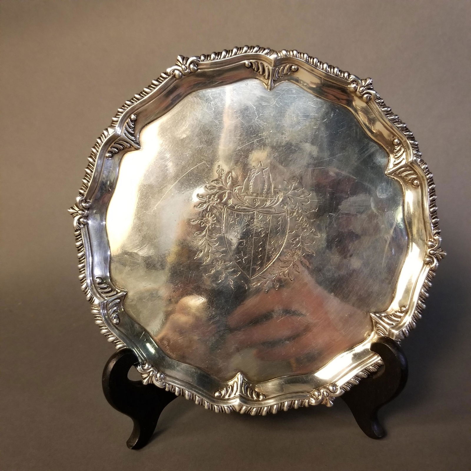 English George III sterling silver salver.: English George III sterling silver salver circa 1771. Possibly Richard Rugg I, London. Central chased heraldry on salver with scalloped edge, raised on three claw and ball feet. Marked with English ha
