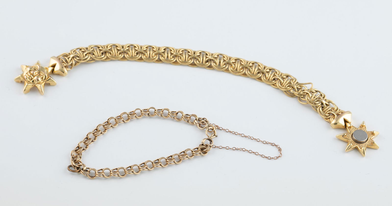 2 14k link bracelets.: A group of two 14k yellow gold link bracelets. Stamped on clasp.++Double linked cable chain with springring clasp. 7". Approx, 7.7g. ++Interlocking link bracelet with magnetic clasp in the shape of a