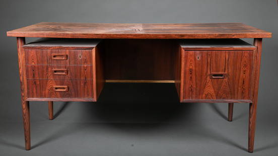 Danish Modern rosewood desk.: A Bornholm rosewood double pedestal desk. Danish. 20th century. Rectangular top over suspended cabinets, on tapered legs. Three pull drawers on front left, one filing drawer on front right. Back has