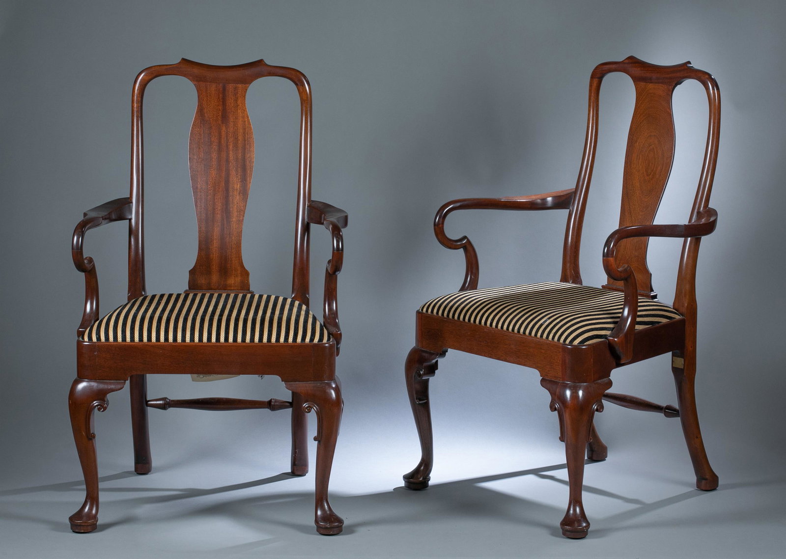 2 Stickley Williamsburg Queen Anne chairs: A group of two Stickley Colonial Williamsburg Reserve Collection Queen Anne arm chairs, Late 20th century. Mahogany primary. Striped upholstered seat. Marked on underside, one has paper tag. 24 1/2" x