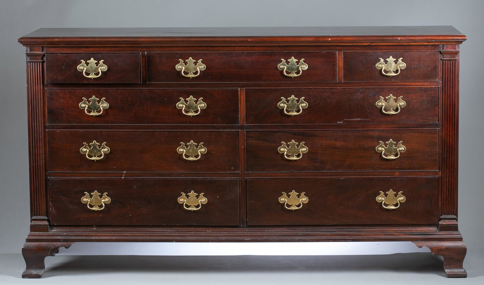 Stickley Chippendale bureau.: A Stickley Chippendale mahogany bureau or dresser, 20th century. Nine drawers with brass batwing pulls and flanked by reeded columns raised on bracket feet. Secret compartment under lower left drawer.