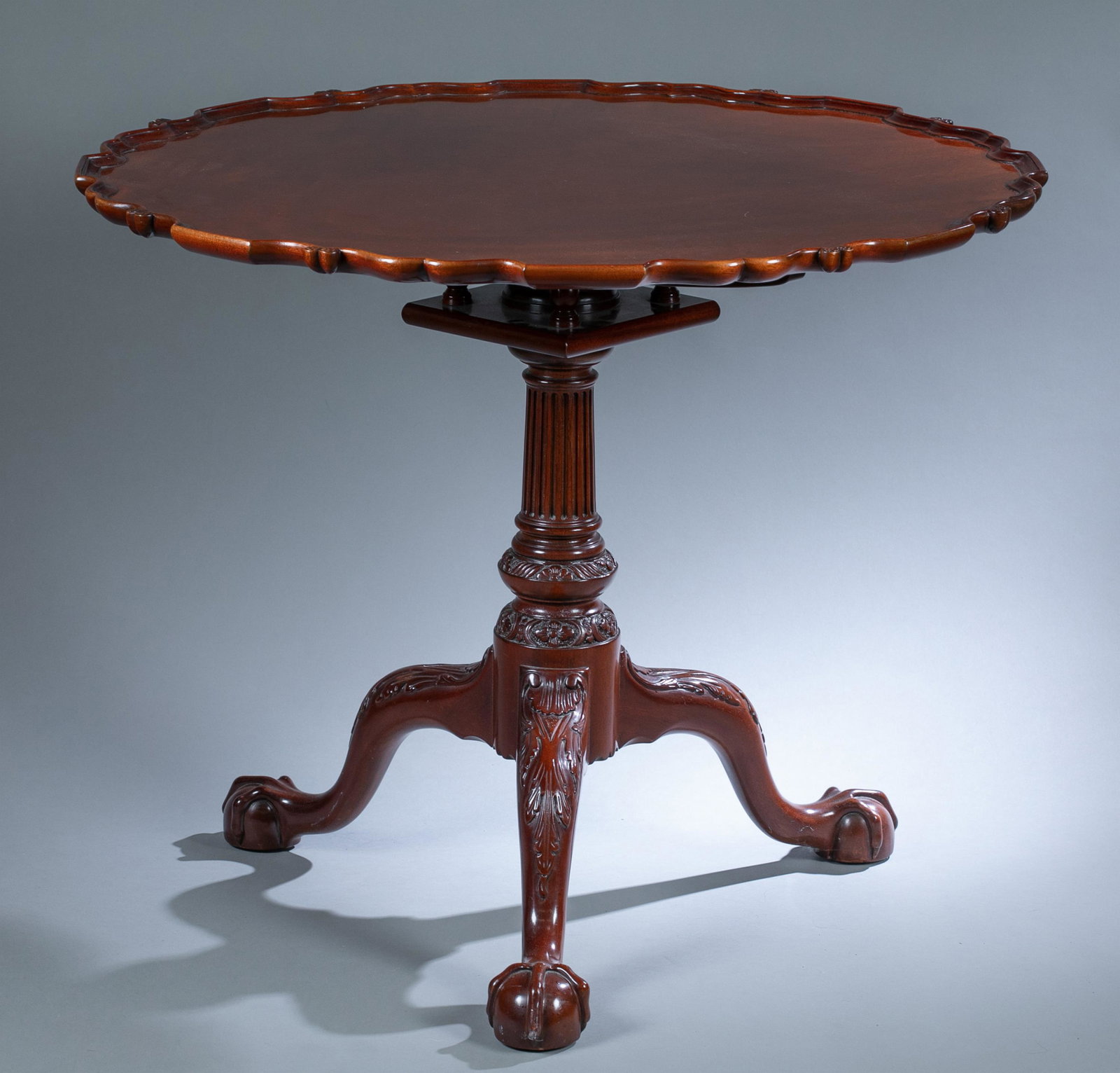 Kindel Winterthur pie crust tilt top tea table.: A Kindel Winterthur Reproduction Philadelphia pie crust tilt top tea table, late 20th century. American birdcage mechanism raised on claw and ball feet. Marked "Winterthur Reproduction" on underside o