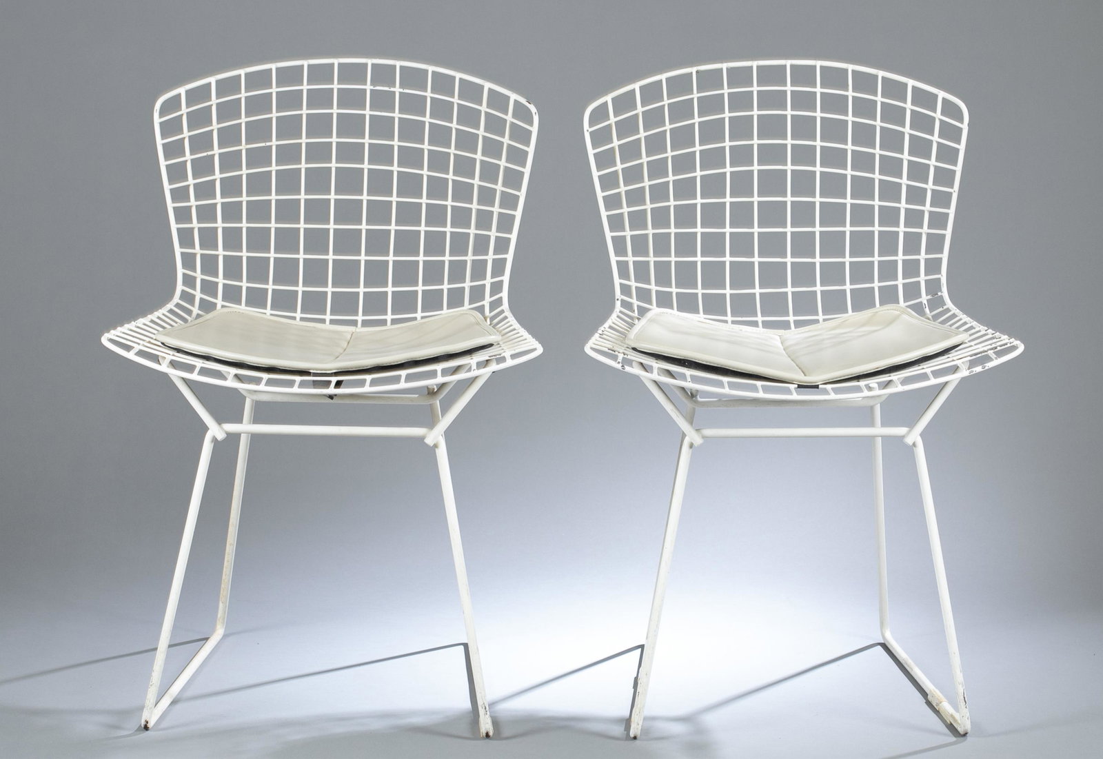5 Bertoia wire side chairs.: A group of five Harry Bertoia (American, 1915-1978) for Knoll wire side chairs. White wire frames with cushions with Knoll tags, four gray and one red. 30" x 22" x 21 1/2"Condition: Paint chipping on 