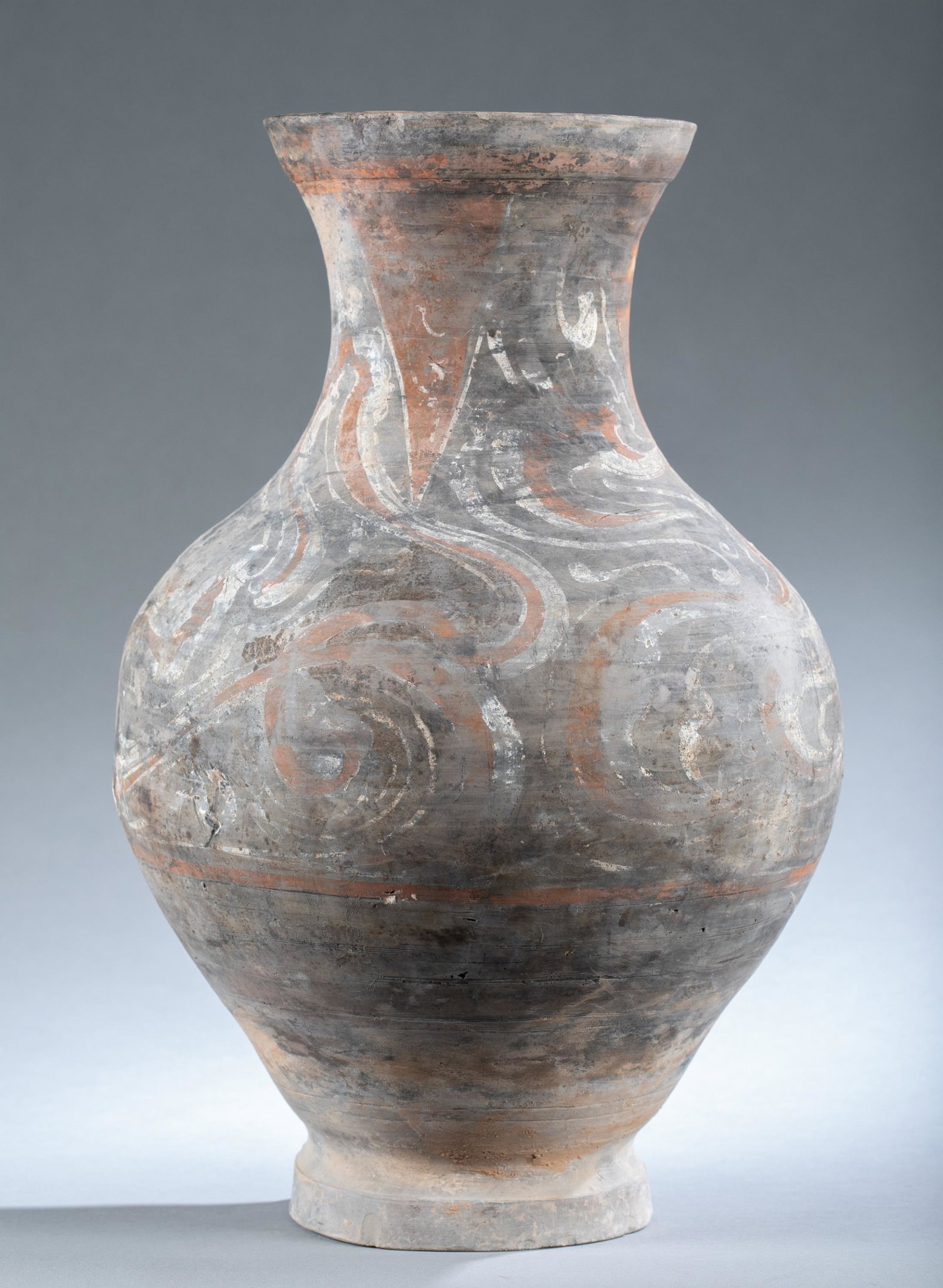 Large Han dynasty pottery jar.: A large Han dynasty (206 B.C-220 A.C) pottery jar. Of tapered globular form, with raised rim. Fire and cloud patterns to the jar. 16 3/4" x 10 1/2".Condition: Paint loss. Age-related scratches and wea