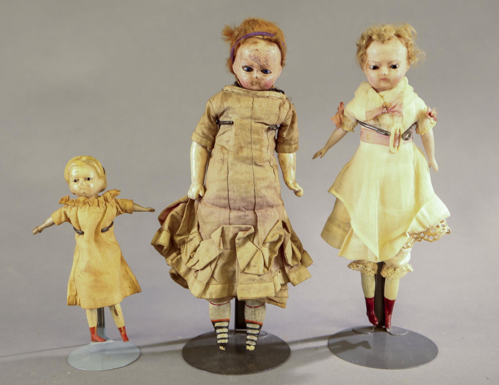 3 Wax over paper mache dolls.: A group of three wax over paper mache dolls, 1860s-1900. ++ Small Alice hairdo wax over paper mache headed with glass eyes. Cloth body with wood limbs. Simple linen dress. 8" long. ++ Wax over paper m