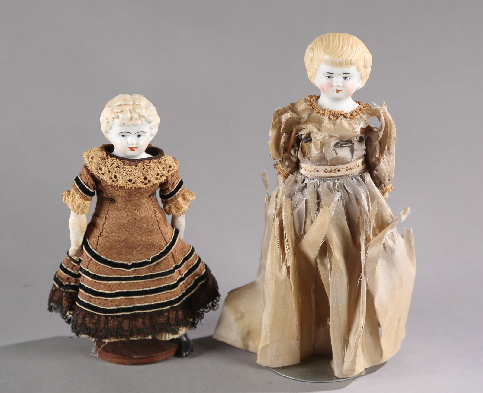 2 German bisque Parian type doll.: A group of two German bisque Parian type dolls. ++ Bisque head with bisque limbs. Molded blonde hair head marked on back "114". Includes bloomers, petticoat and silk dress in poor condition. 9" long. 