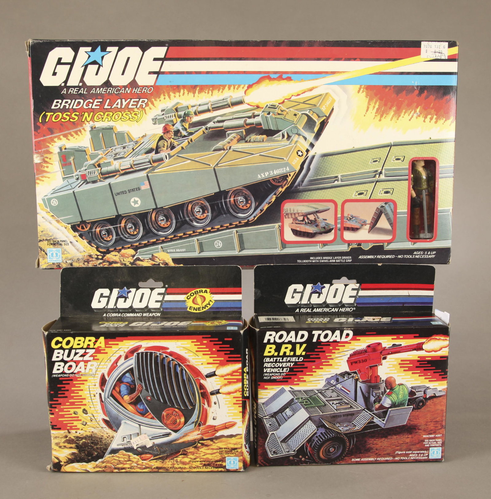3 G.I. Joe vehicles MIB.: A group of three G.I. Joe A Real American Hero vehicles Mint on Box. ++ 1984 Bridge Layer Toss N' Cross with driver 10" x 18 1/2" x 3 1/2" ++ Cobra Buzz Boar in box. 8 1/4" x 8 1/2" x 2 1/2". Road Toa