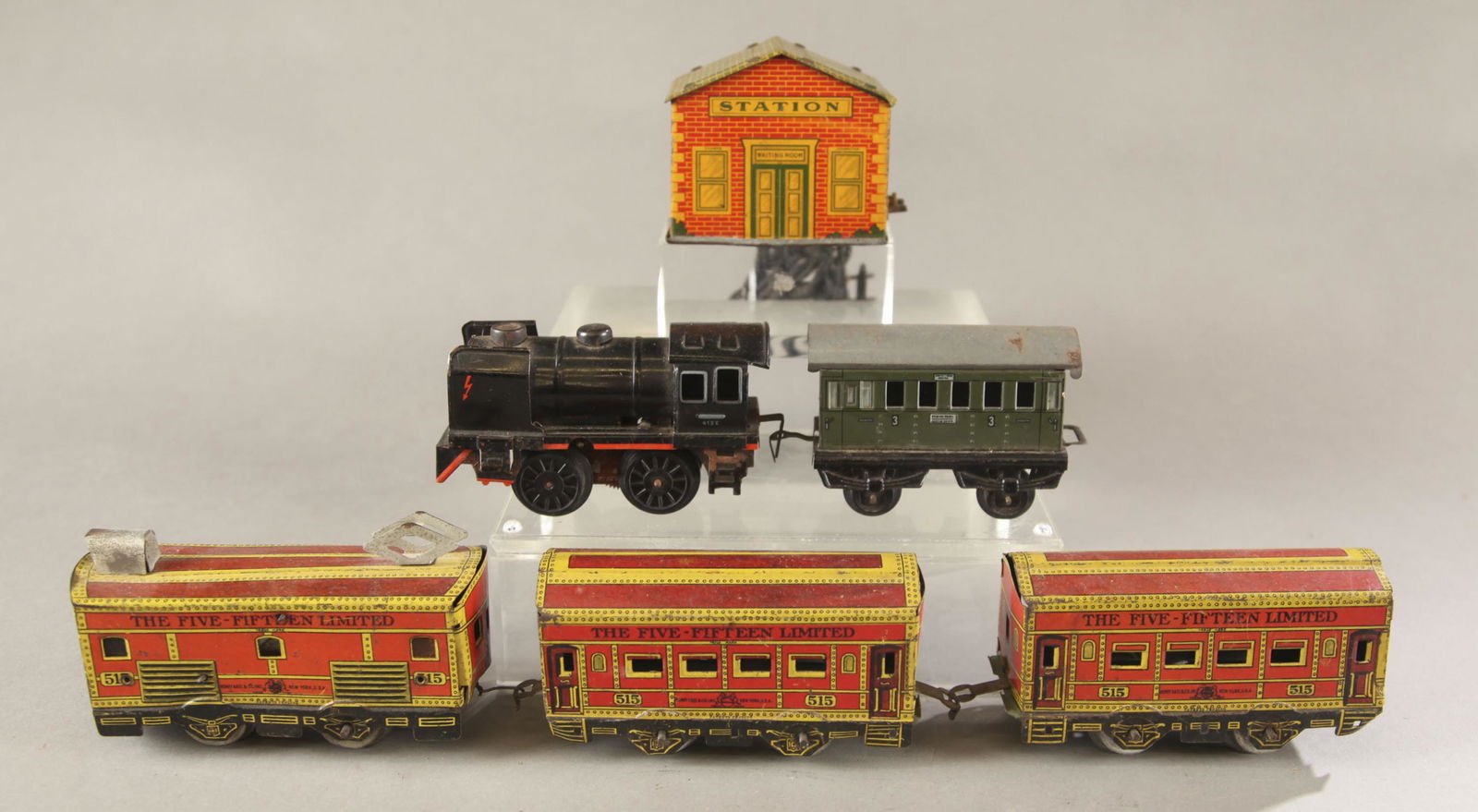 2 Prewar tin litho train sets.: A group of two prewar tin lithograph train sets. ++ Karl Bub 413E windup engine and coach car. 2 1/2" x 4 3/4" x 2". Coach car 2 1/2" x 4" x 1 3/4". ++ Henry Katz & Co. The Five-Fifteen Limited electr