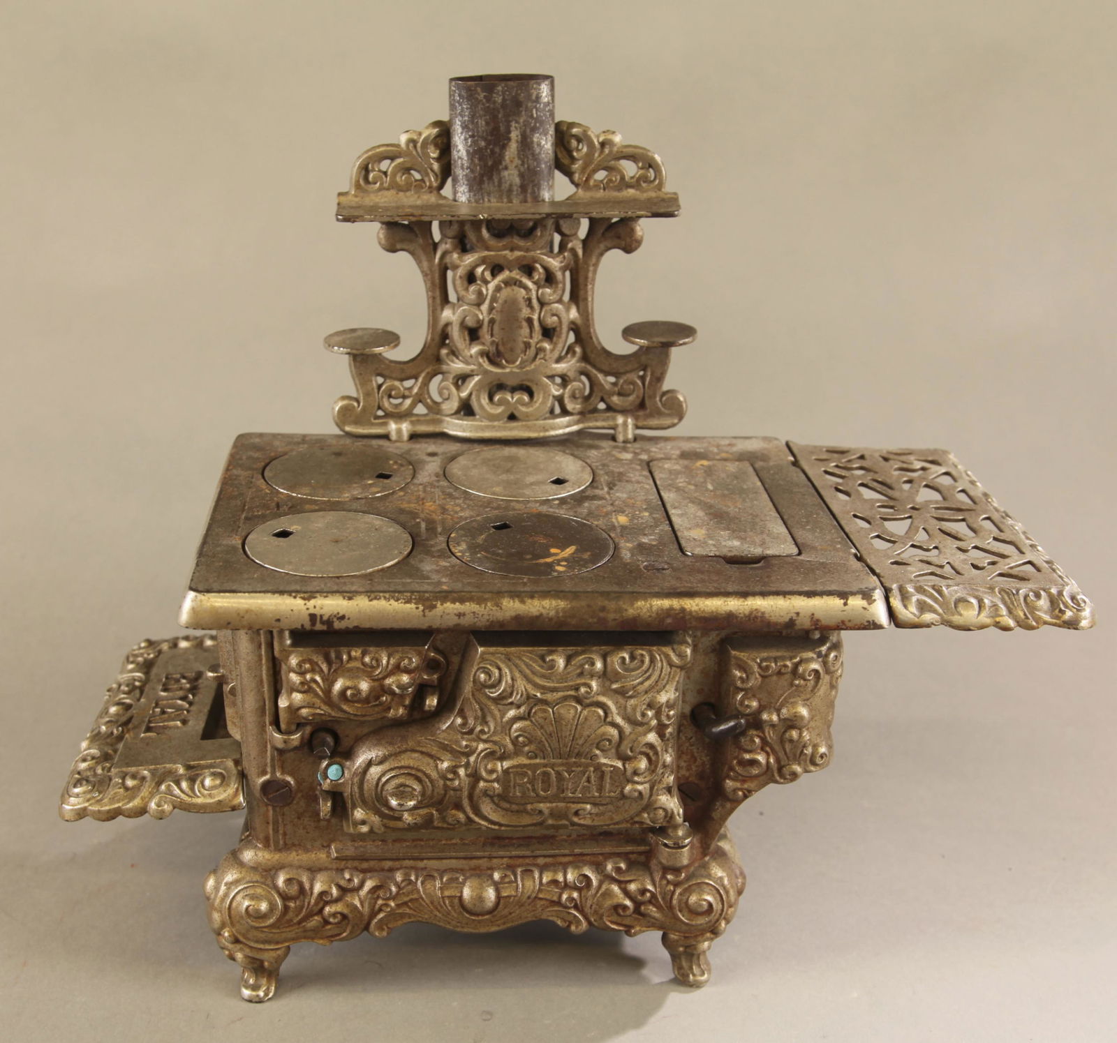 Large Kenton "Royal" cast iron coal stove.: Large Kenton "Royal" nickel plated cast iron coal stove, circa 1920. Four burner with four covers. Includes back piece with two trays. 12" x 14" with grates and 6" tall.