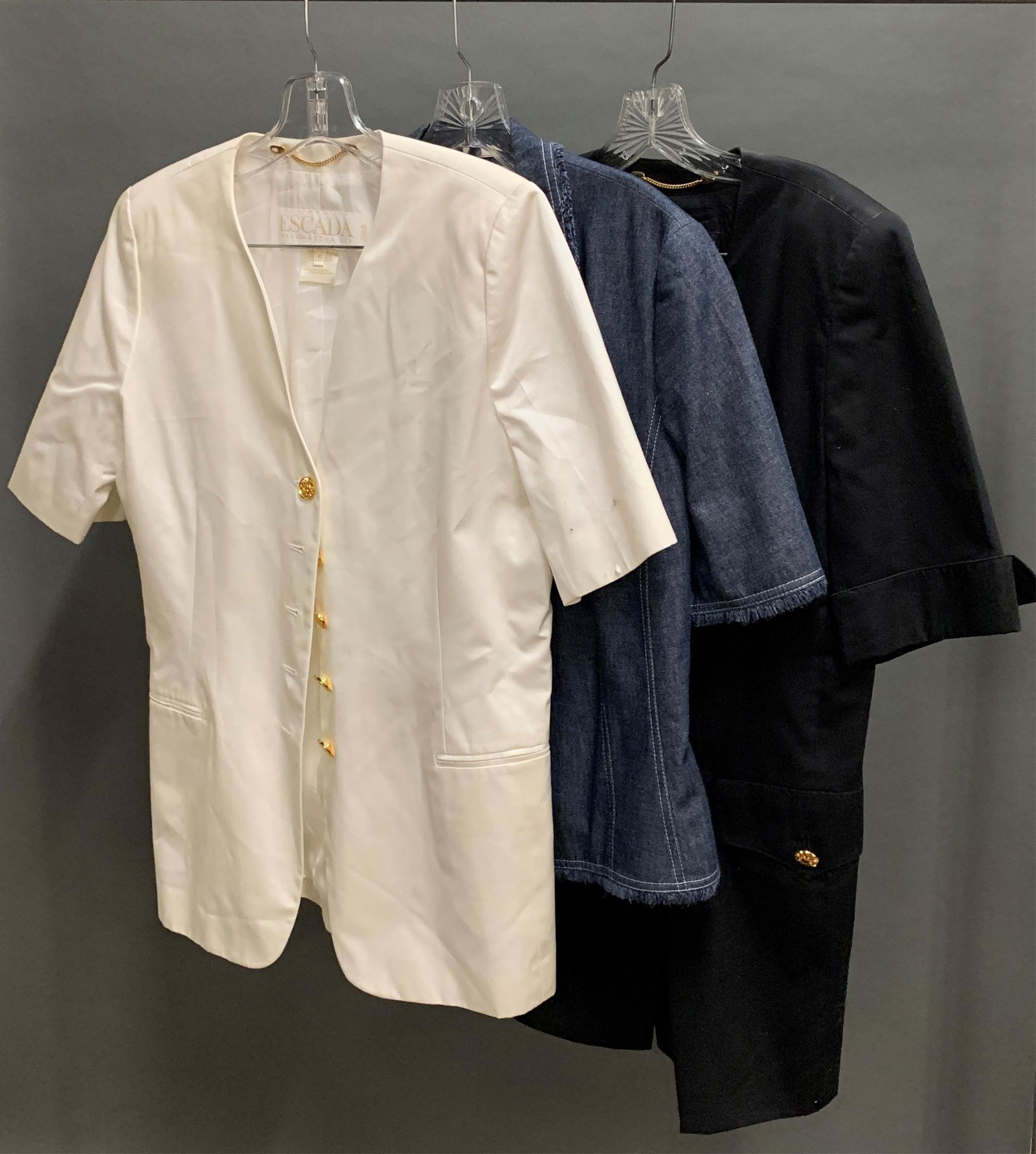 3 Escada short sleeve jackets.: A group of three Escada short sleeve jackets. ++ Black double breasted jacket. Size 42. ++ White jacket. Size 40. ++ Denim jacket. Size 40.