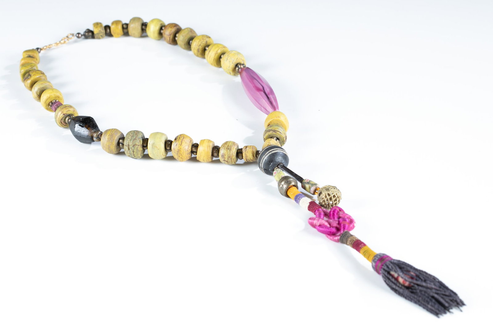 Prayer bead style necklace.: A prayer bead style necklace with a cord wrapped tassel and lucky knot. Large yellow green beads separated by small metal beads. Hook clasp. 27 1/2". Pendant: 9". Provenance: The Estate of Giraud V. F