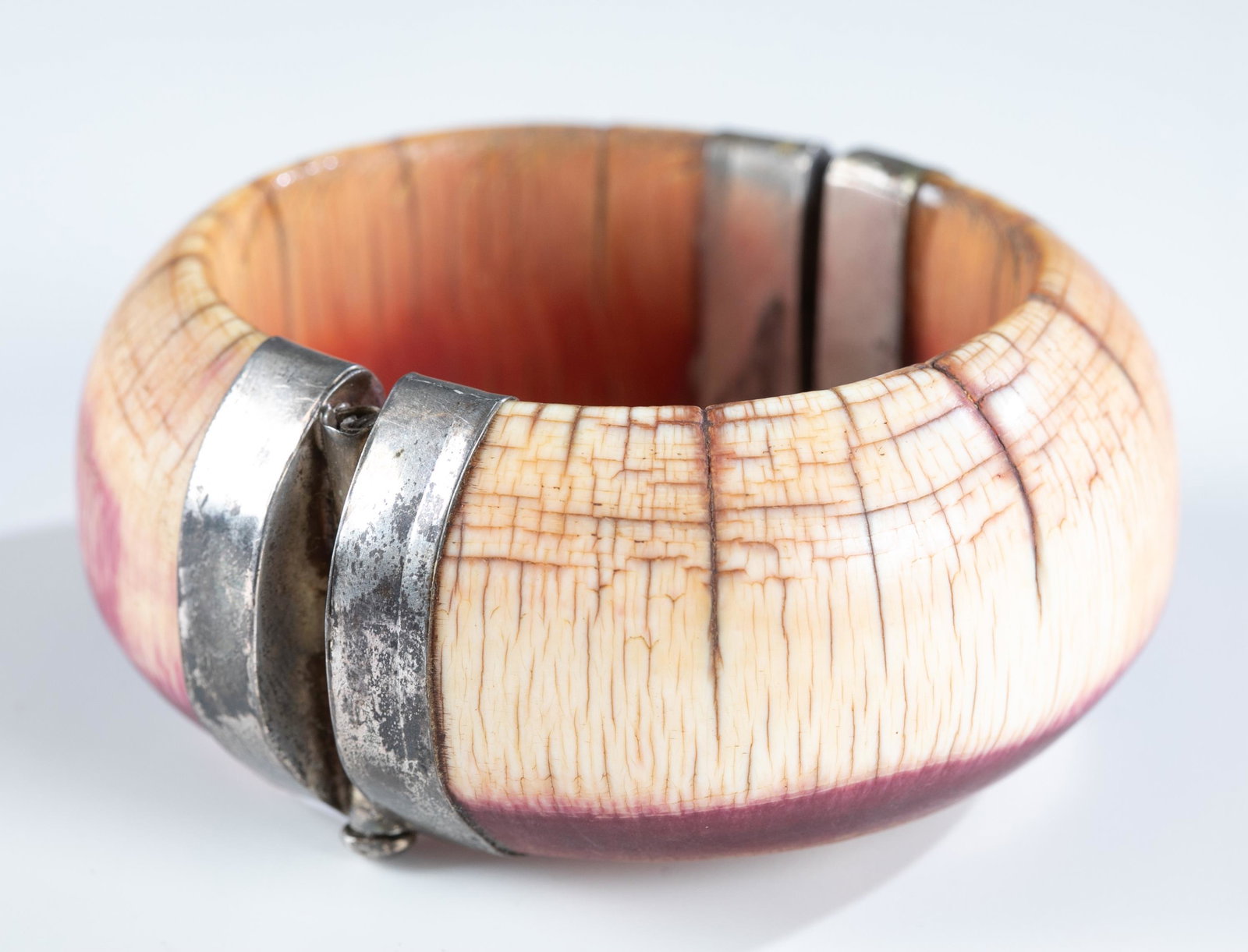 East Indian horn hinged bangle.: An East Indian style horn hinged bangle with pin clasp. Purple discoloration around base. 7 1/4". Provenance: The Estate of Giraud V. Foster.The Estate of Giraud V. Foster.