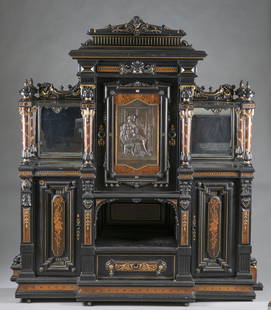 American Aesthetic Movement cabinet.: An American Aesthetic Movement parcel gilt cabinet. Circa 1865-1870. New York. Pine secondary with rosewood and ebonized primary. Scroll top backslash with central mask and swag frieze, and mother of