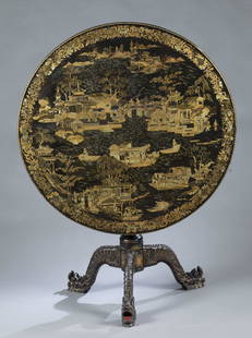 English Chinoiserie tilt top tea table: An English Chinoiserie tilt top tea table. 19th century. Black with gilt design, round top setting on tripod base with carved lion feet. Piece to keep top in place is missing. 29 1/2" x 36" dia.