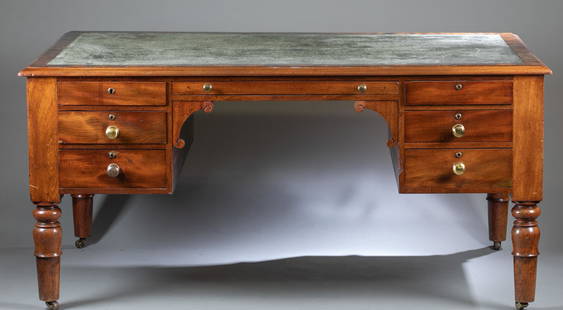 English partners desk.: An English partners desk on turned legs. Mahogany primary and pine secondary. Leather top with glass top. Mirrored desk fronts with six drawers astride a center extendible leather topped writing