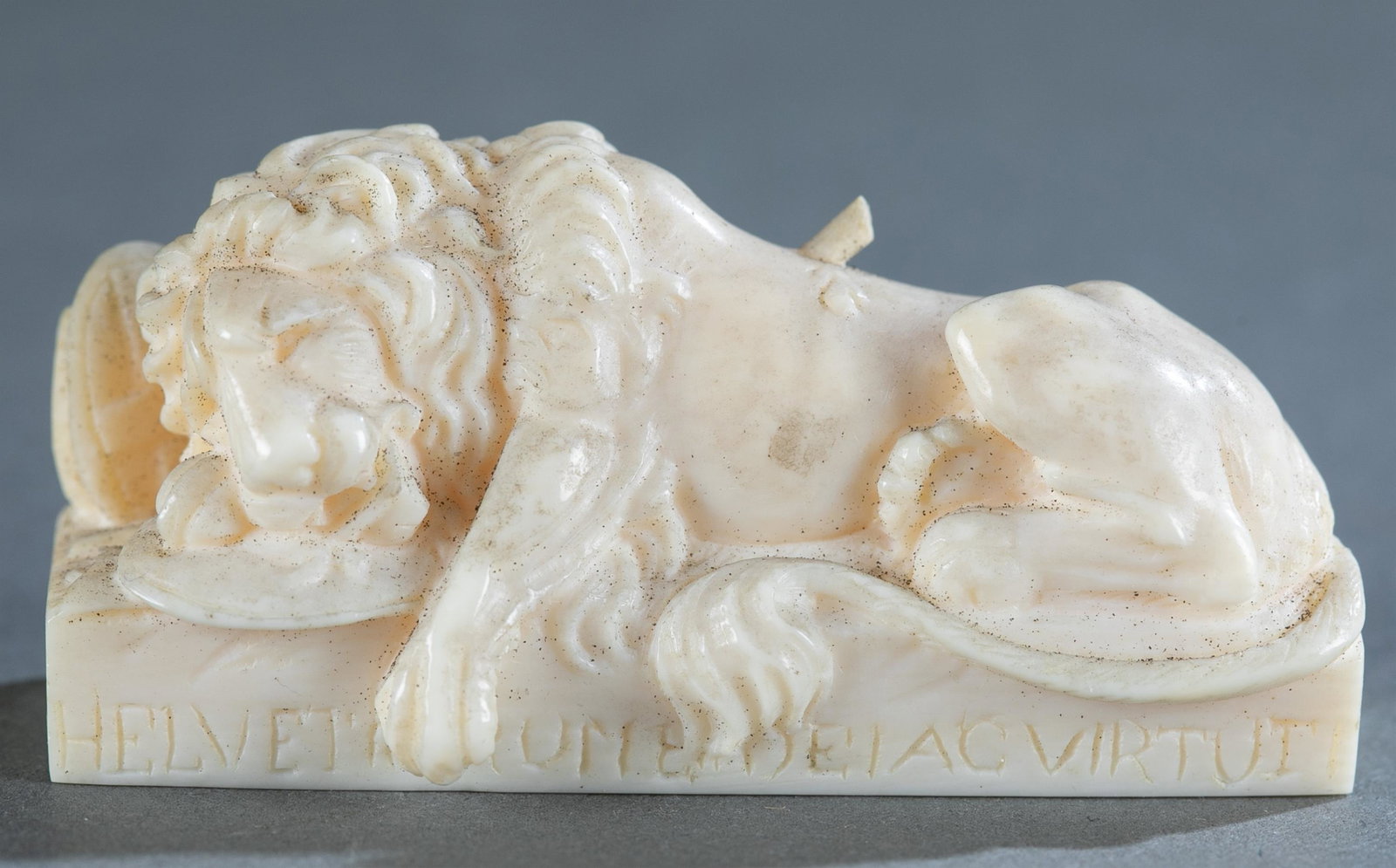 Carved ivory Lion of Lucerne sculpture.: Carved ivory Lion of Lucerne sculpture. Reclining lion with broken spear in back leaning on two shields, one with Fleur de Lis and other coat of arms of Switzerland. Below is latin inscription "Helvet