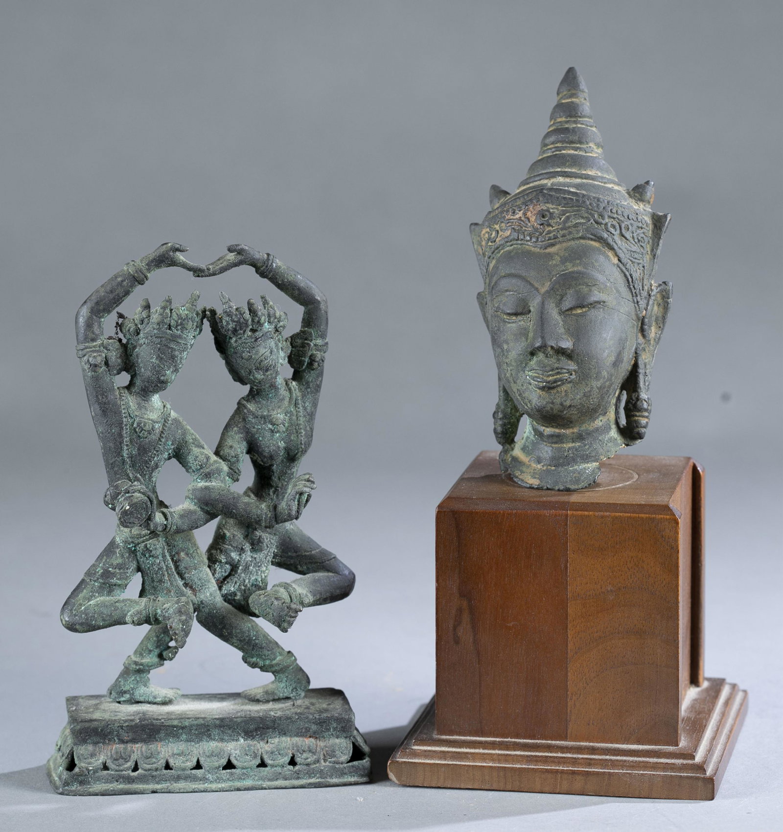 2 Thailand bronze buddha figures.: A group of two Thailand bronze buddha figures. Including a mounted Buddha head on the wooden base. 8 1/2" x 4" x 4". Without base: 4 7/8" x 2 1/2" x 2 3/4". A dual dancing Buddha figures. Mounted on t
