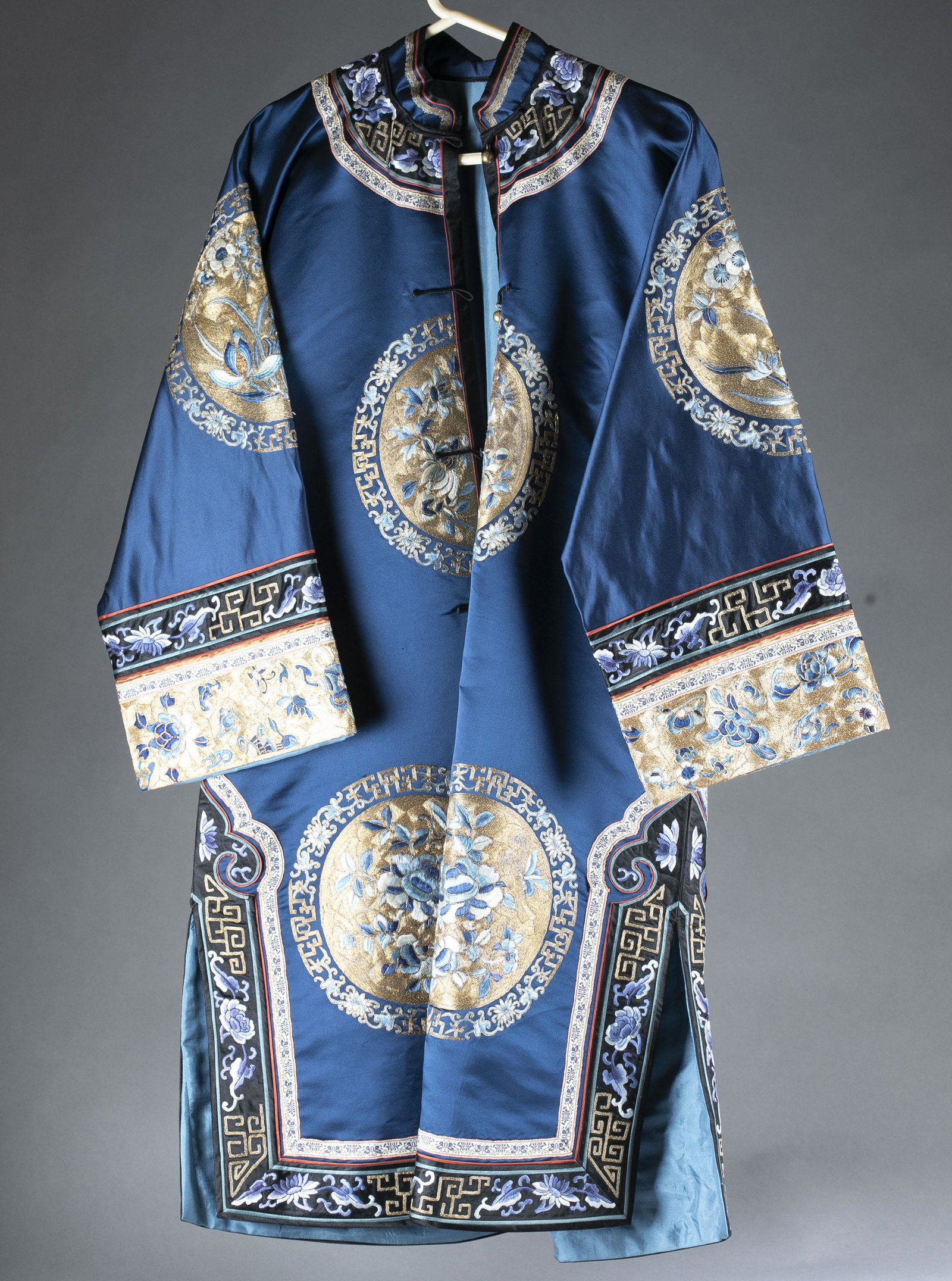 Qing dynasty Han women's silk dress.: Qing dynasty Han women's silk dress. General in navy blue ground. Embroidered with blue floral designs. Vertical buttons. 43 1/4" x 61". Condition: Overall in good condition. Some minor tears to the s